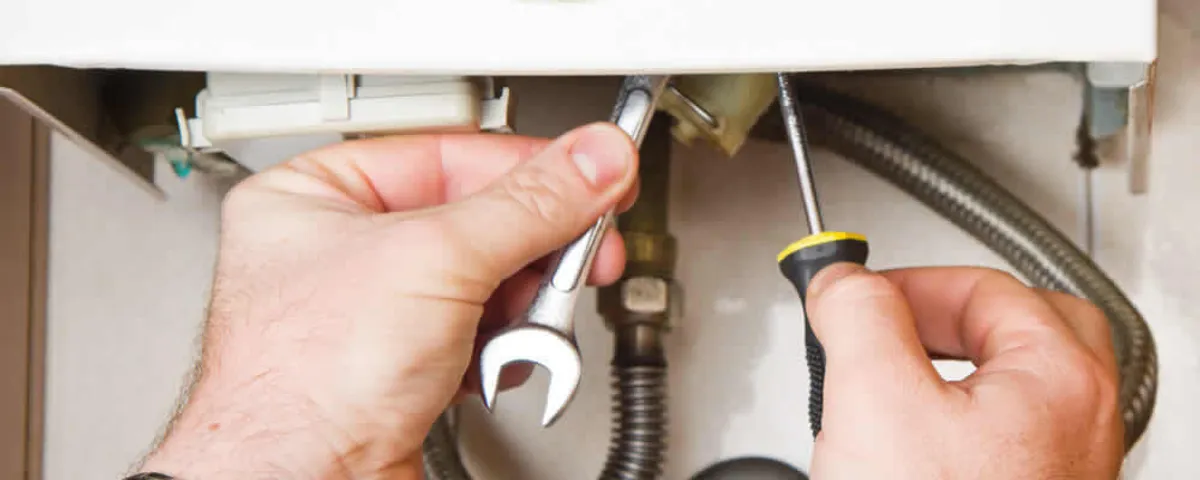 Boiler repair technician tightening pipe fittings and connections in San Antonio, TX