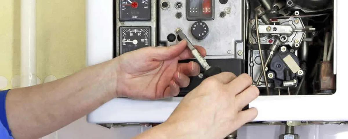 Heating repair technician adjusting boiler controls and components in San Antonio, TX