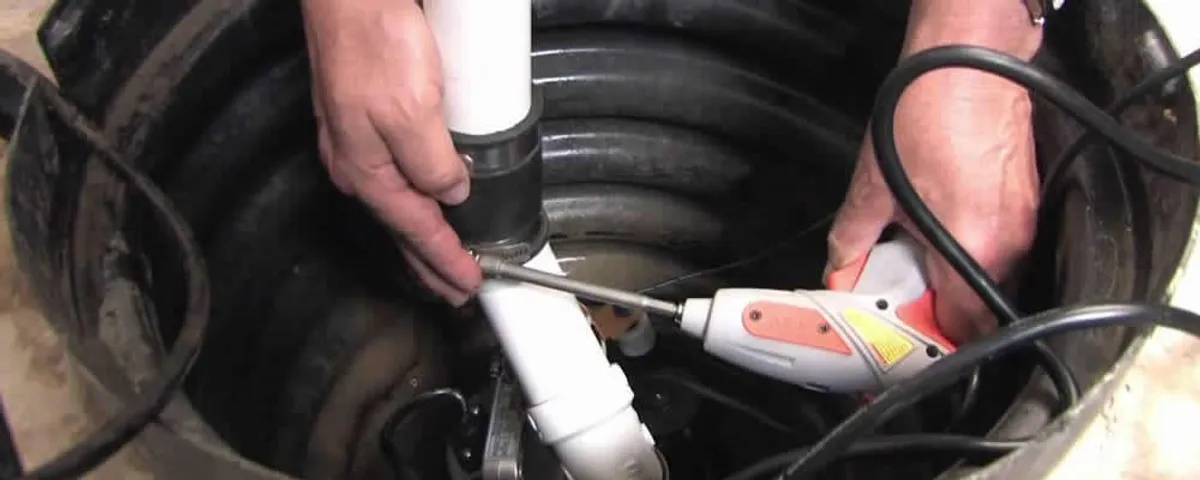 Sump pump installation technician connecting PVC discharge piping in San Antonio, TX